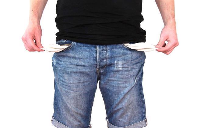 A man holding his pockets showing that they are empty