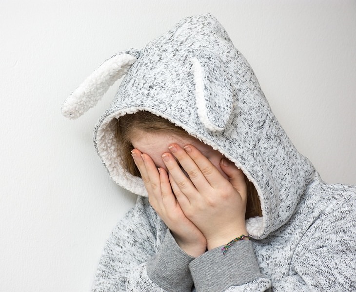 girl in a bunny hoodie with her hands in her head
