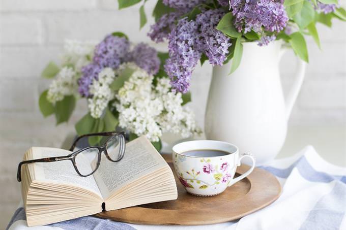 A coffee table with a mug, book, and vase on top of it