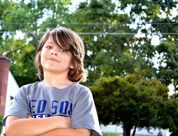 boy smiling at camera with his arms crossed