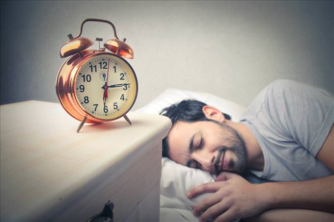 man asleep with alarm clock
