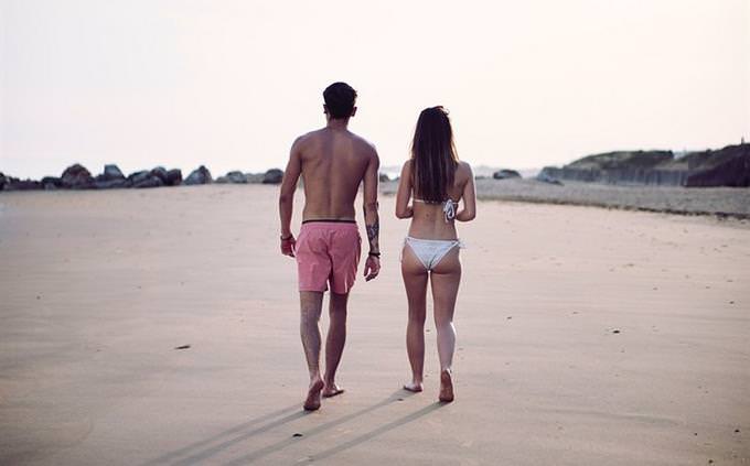 A man and a woman walking with bathing suits