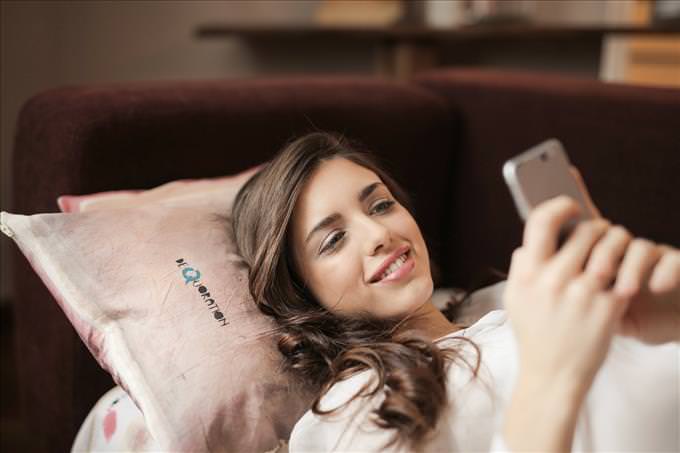 woman texting in bed