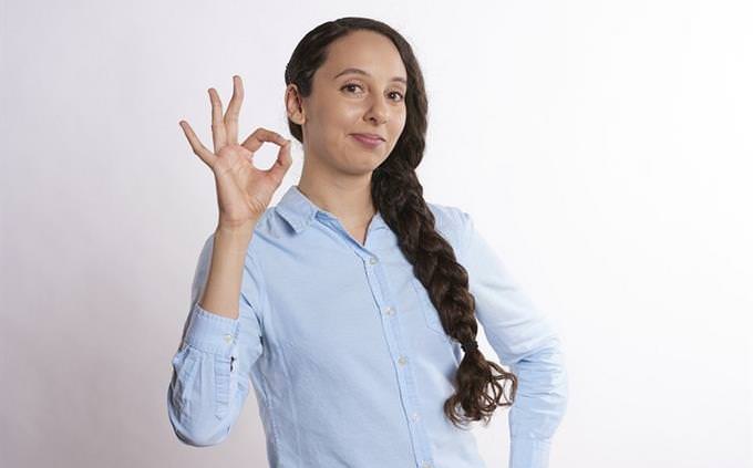 A woman signing “OK”