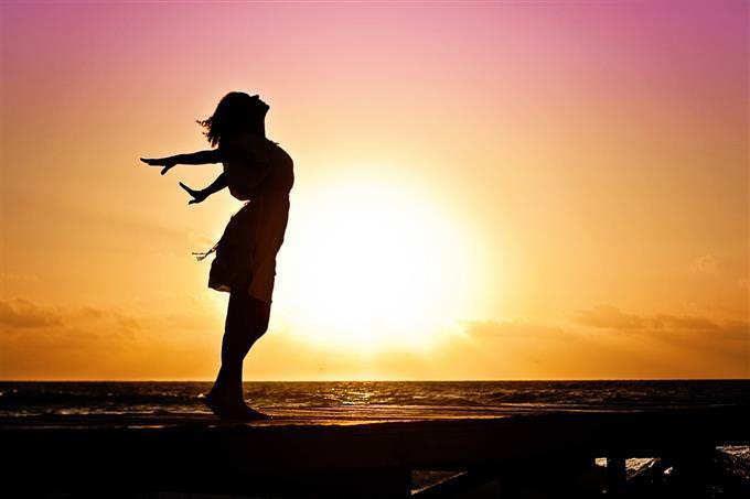 A woman in front of a sunset