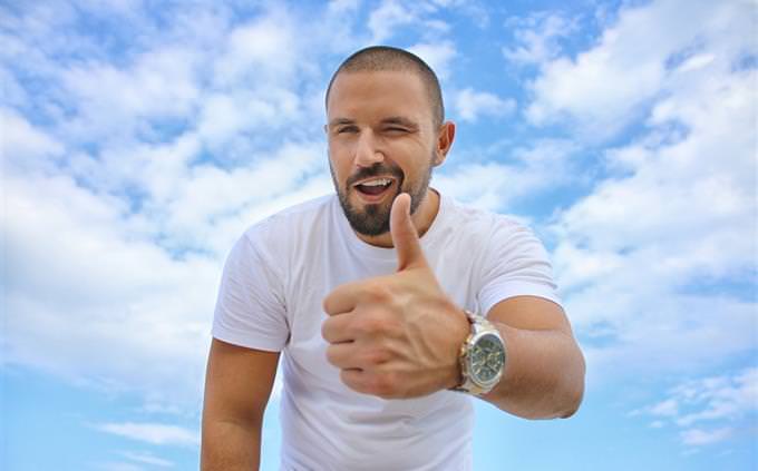 A man holding his thumb up to the camera