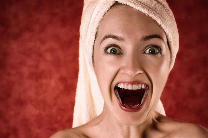 A woman laughing with a towel on her head