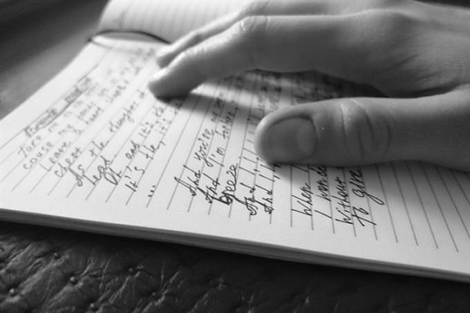 A man placing his finger on words in a book