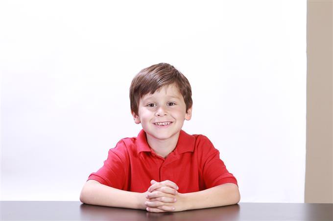 A boy sitting at a table and smiling