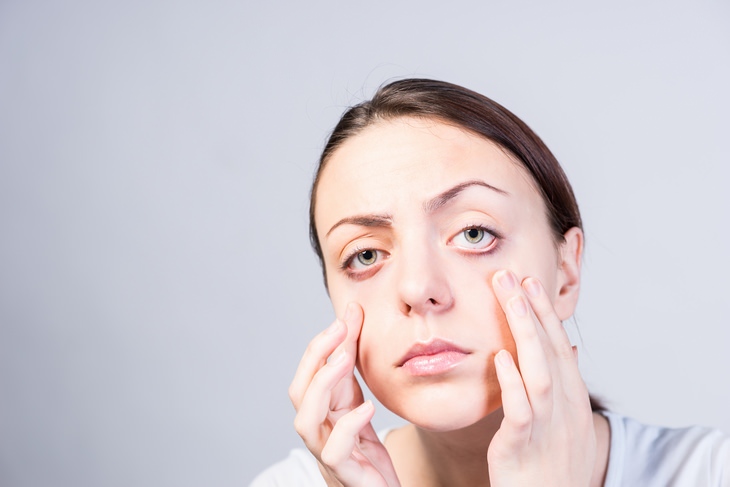 a woman pressing on her lower eyelids