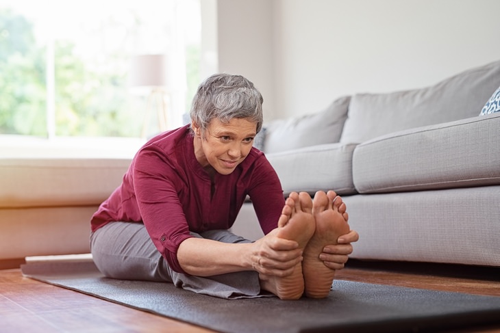 old woman doing a forward fold