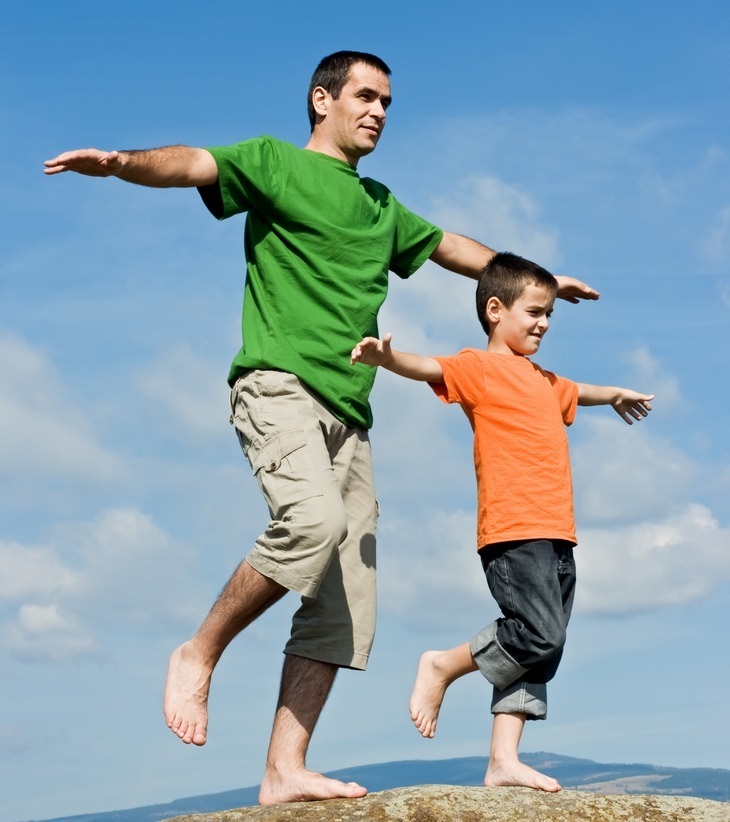 a man and a boy both balancing on one foot