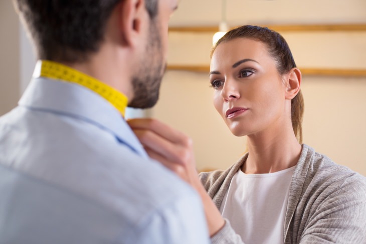 a tailor measuring a man's neck