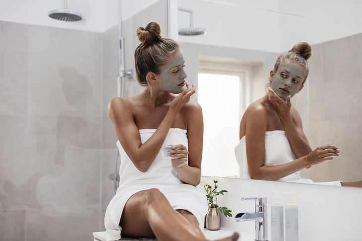 a woman in a bathroom wearing a face mask