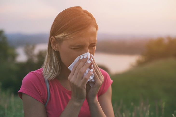 Myths about the Cold and Flu woman blowing nose with tissue