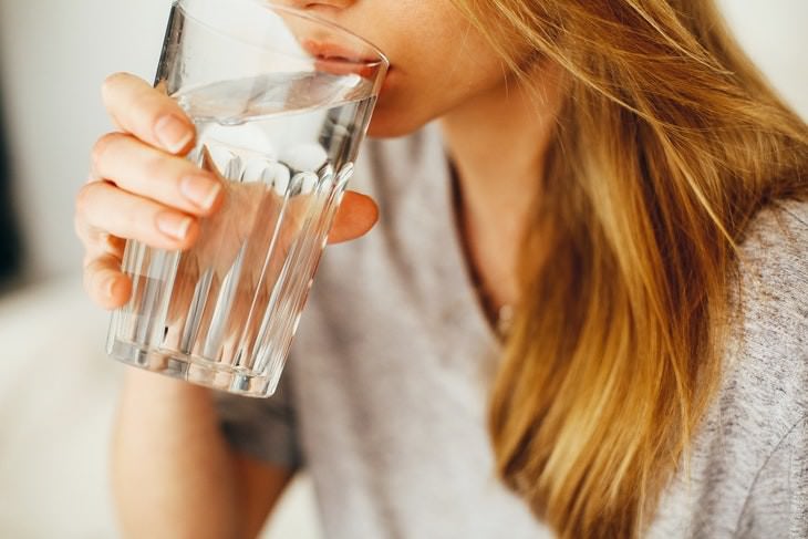 traveler's bloating causes and fixes woman drinking water