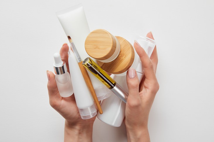 bad habits for skin and hair woman holding skincare products in her hands