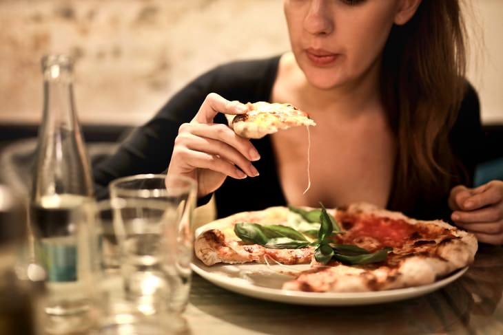 Heavy Evening Meals Affect Women’s Heart Health woman eating pizza for dinner