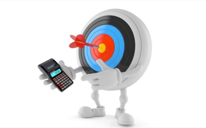 a bulls-eye target with legs holding a calculator