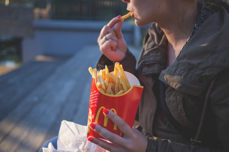 most and least addictive foods woman eating french fries