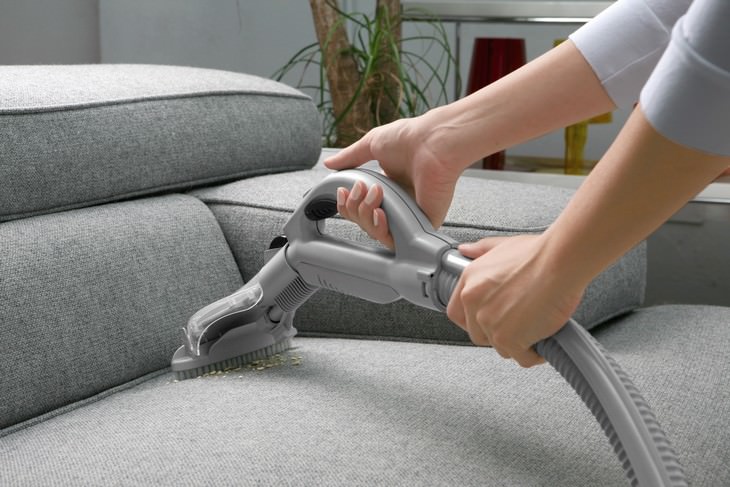 Furniture Cleaning Mistakes woman vacuuming a couch