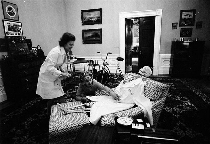 historical photos: First Lady Betty Ford, wife of U.S. President Gerald Ford, dresses with her assistant a skeleton figure on the president's chair in his second-floor White House study - October 30, 1974.