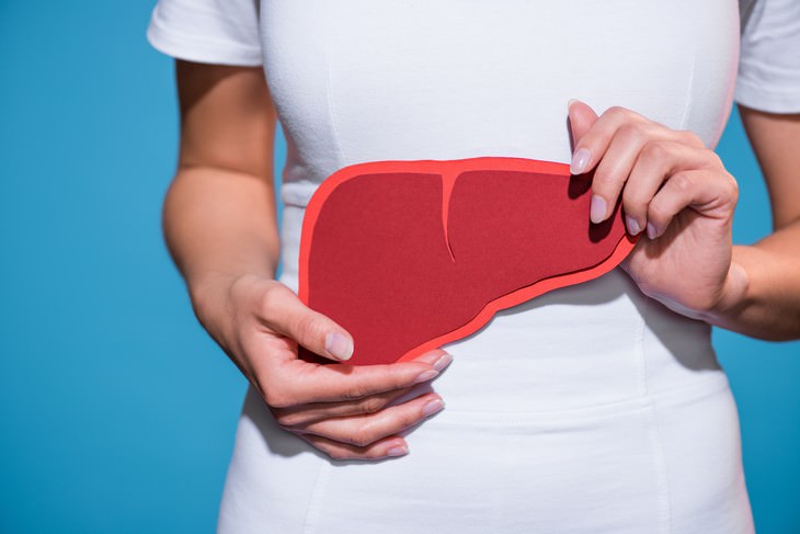 10 Greatest Medical Discoveries of the Year 2019 woman holding a picture of a liver in front of her abdomen