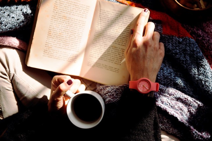 language learning woman reading a book while drinking coffee