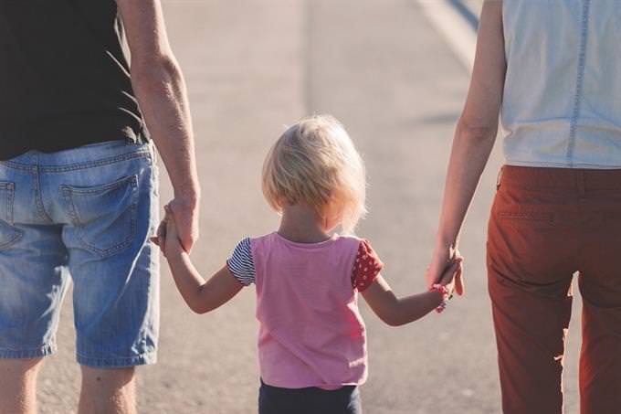 quiz toddler holding parents' hands