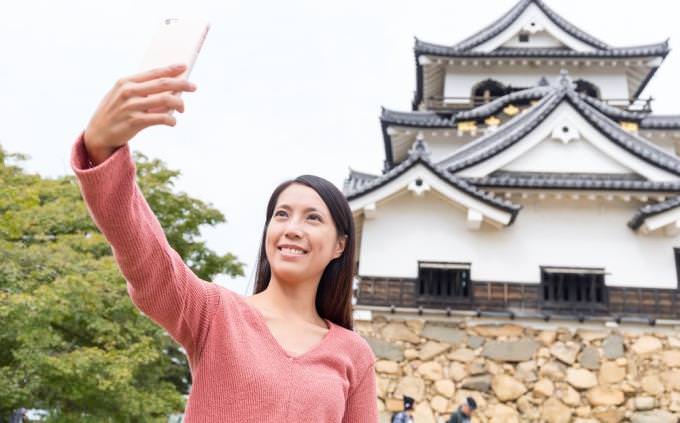 japan quiz: woman taking a selfie in front of a pagoda