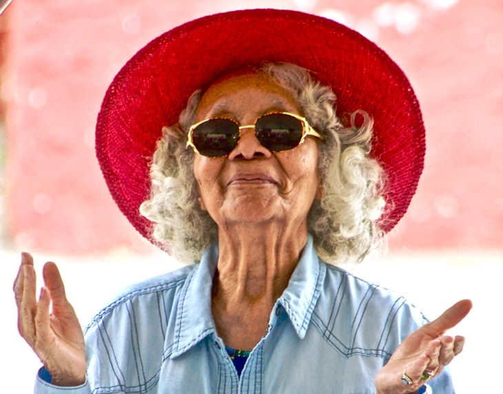 wrinkle causes elderly woman wearing glasses and red hat