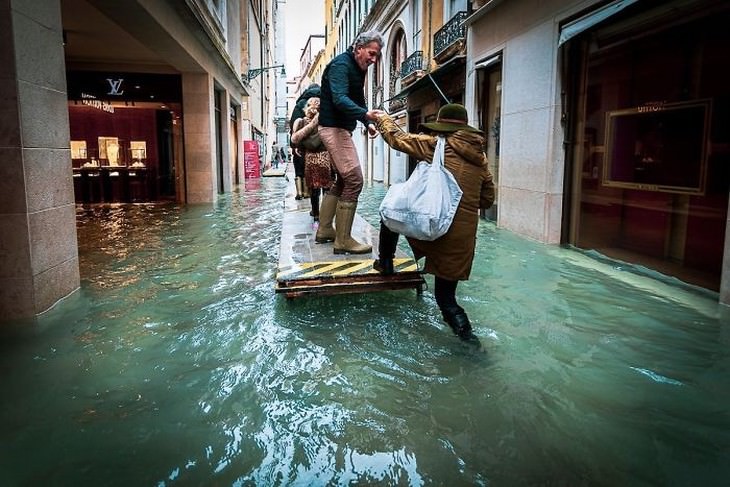 Flooded Venice people getting on a raft