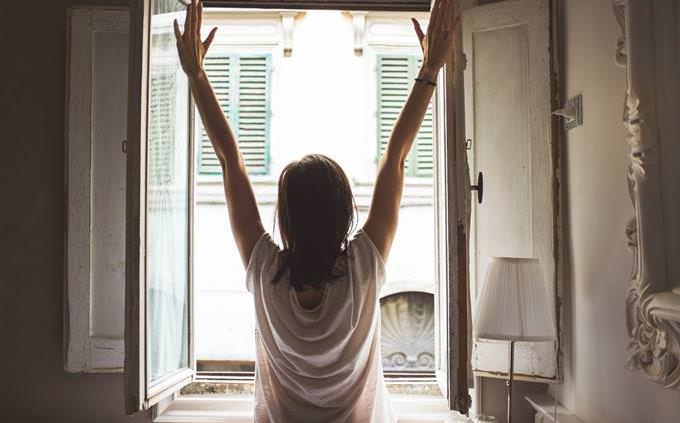 woman stretches in front of window