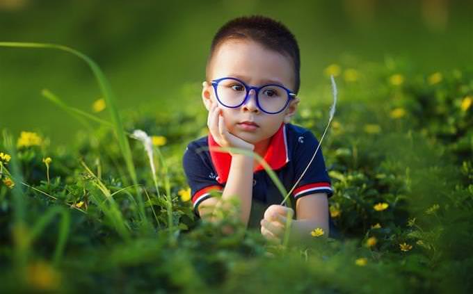 child sitting on the grass looking sad