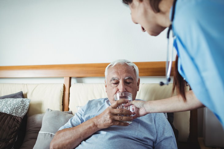 dehydration in seniors nursery worker helping elderly man drink water