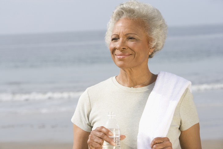 dehydration in seniors senior woman holding a bottle of water on the beach