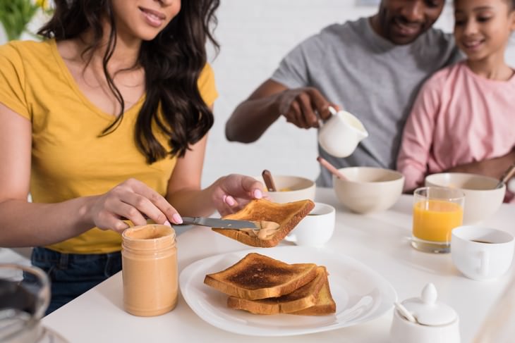 foods safe to eat past expiration date family breakfast woman spreading peanut butter onto bread