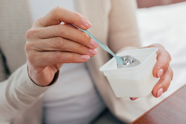 foods safe to eat past expiration date woman eating yogurt with a spoon
