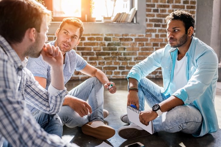 irrelevant slang three men sitting on the floor and discussing something serious