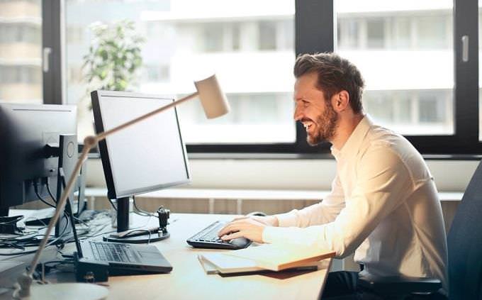 man sits in front of computer