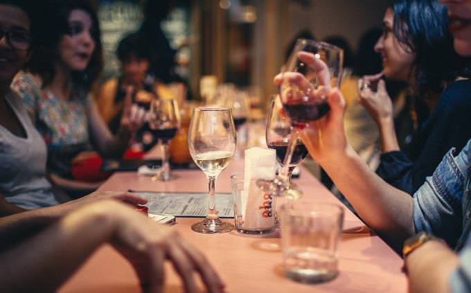 Friends toasting a glass of wine at a table