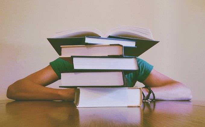 pile of thick books on a table