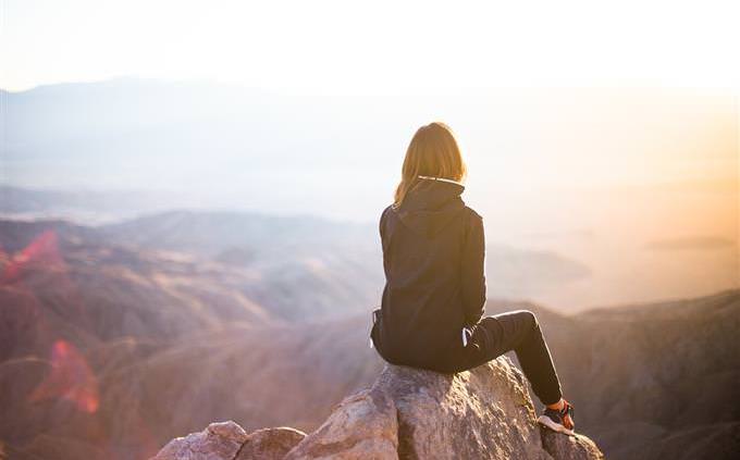 a woman sitting on a cliff