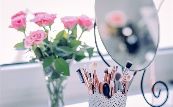 mirror, makeup brushes and flowers