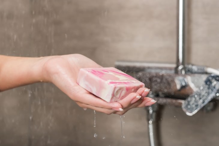 Experts Reveal: How Often You Should Really Shower, woman holding 