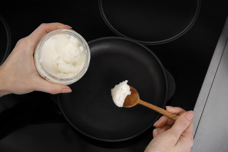 Refined vs Unrefined Coconut Oil adding coconut oil to frying pan