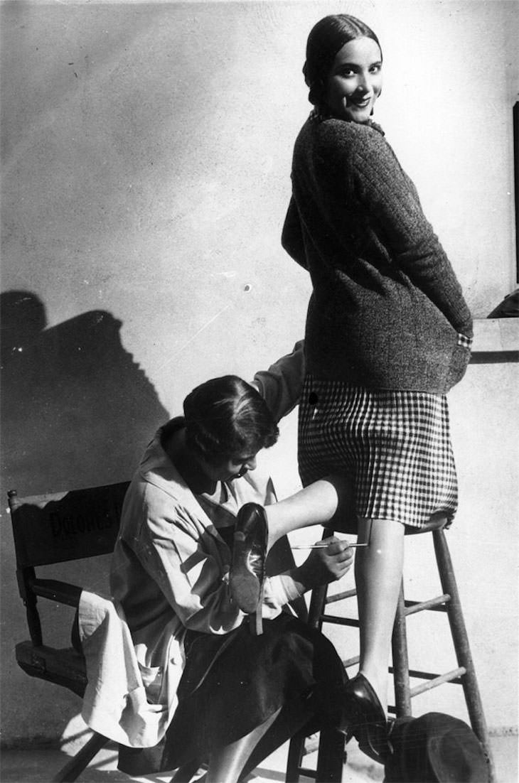 Past Beauty Practices That Seem Strange Today, A woman aaving a seam painted onto her leg, tom it appear that she is wearing stockings, 1926