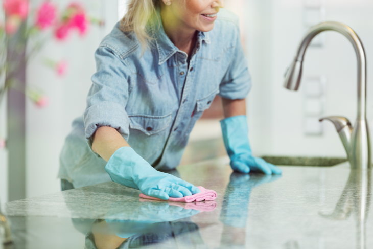 Things You Shouldn't Clean With Vinegar woman cleaning granite counter