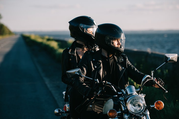 Items You Should Never Buy Used couple on motorcycle wearing helmets