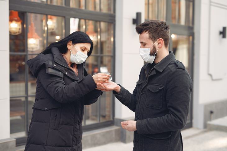 Pfizer Vaccine woman putting hand sanitizer in a man's palm